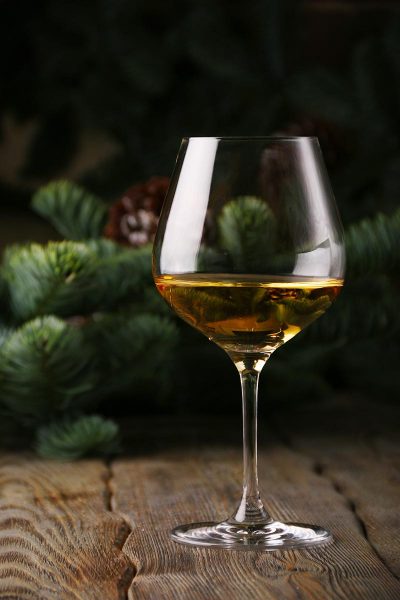 glass of white wine christmas background. New Year celebration concept.